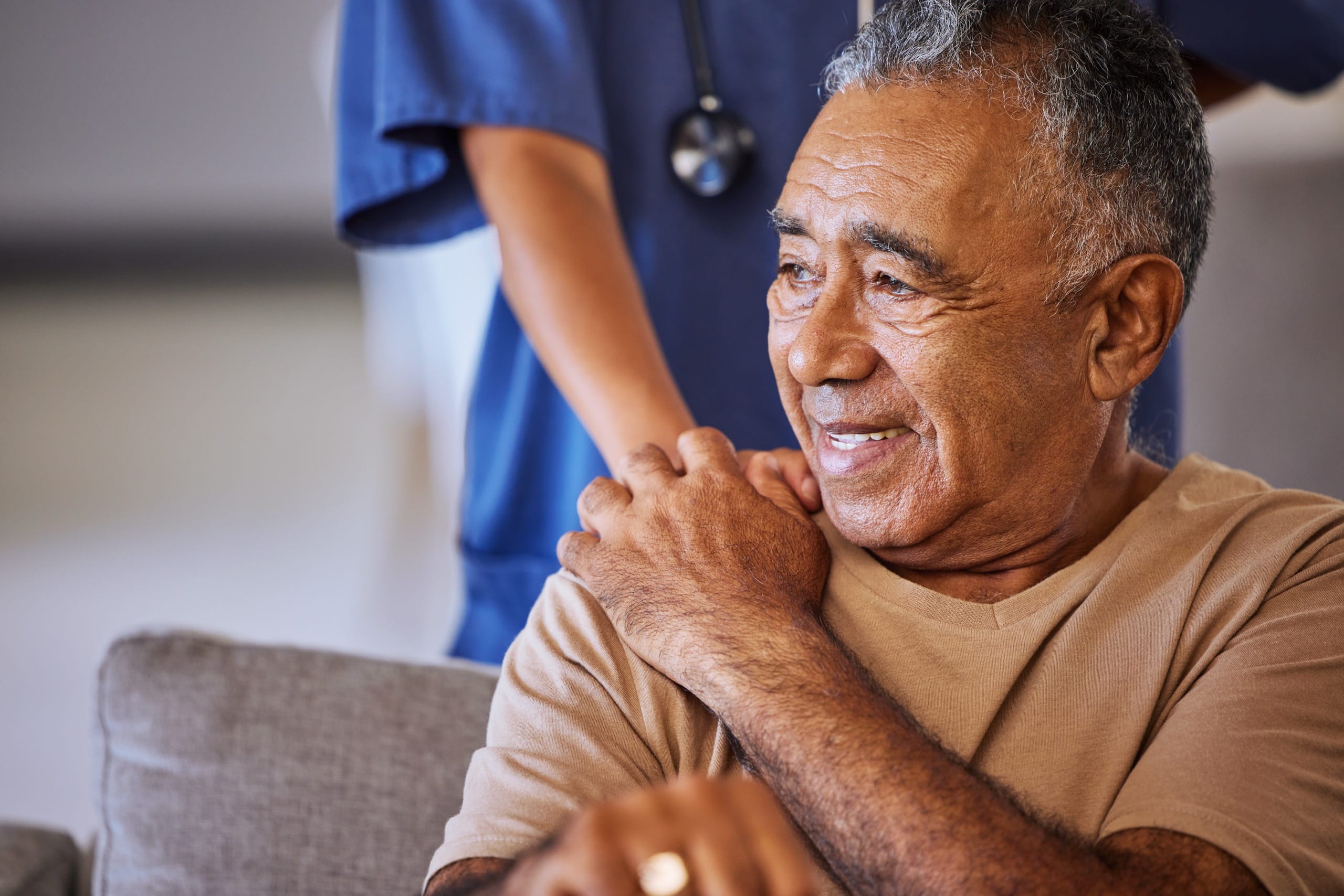 man in hospital smiling holding hand of doctor